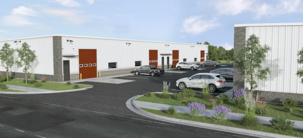 Modern warehouse with parking lot and loading docks under a clear sky.